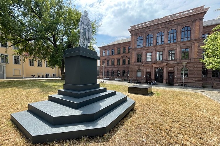 Auf dem Platz vor dem Rutheneum ist ein Sockel mit einer Figur aus Kar