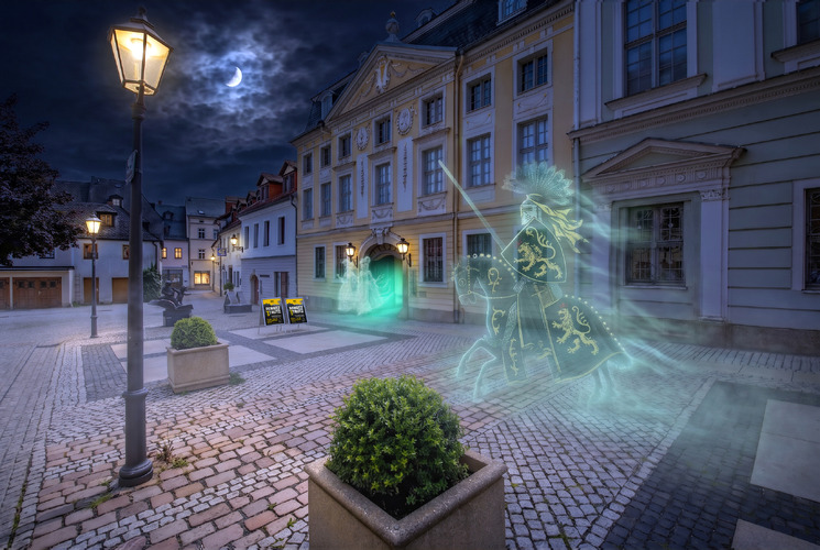 Eine nächtliche Pflasterstraße vor historischer Kulisse des Vogtlandmu
