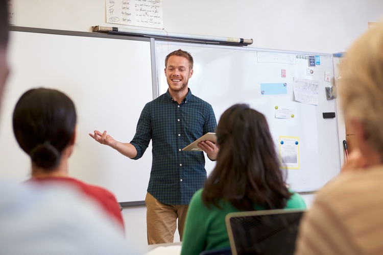 Ein Lehrer erklärt oder präsentiert Lernenden etwas.